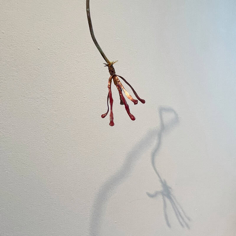 detail of the sculpture of a vase with a flower made from construction waste, combined with natural materials, serves as a metaphor for beauty emerging from discarded remnants.