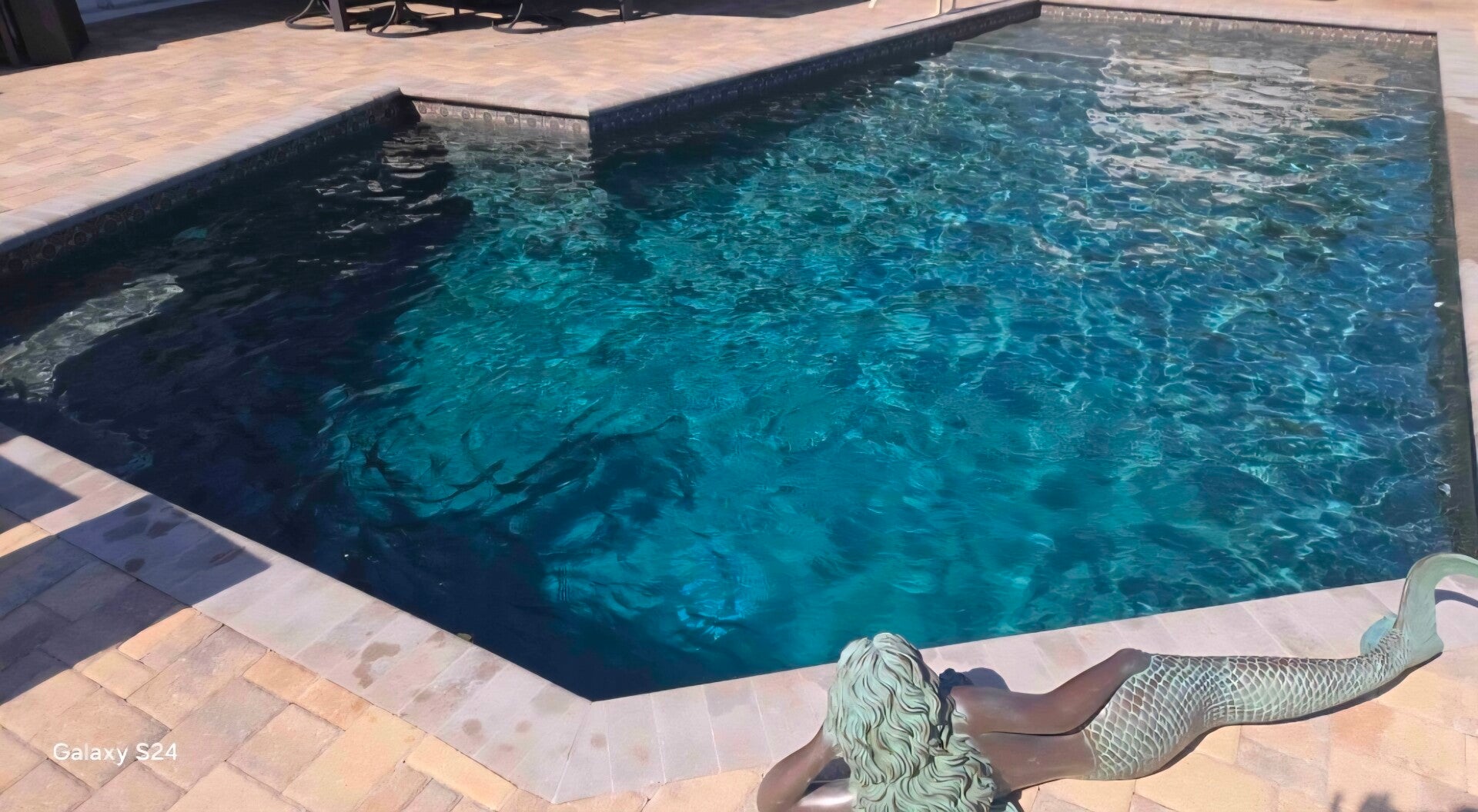 Clear blue pool with mermaid statue serviced by Aqua Glimmer Pool Services in Belleair, FL