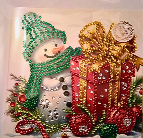 Snowman wearing green with large present Christmas card