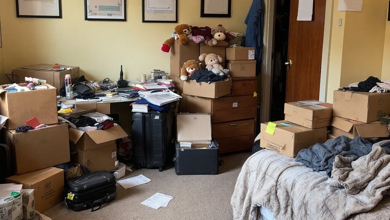 Szobabelső rendetlenséggel és dobozokba összegyűjtött tárgyakkal