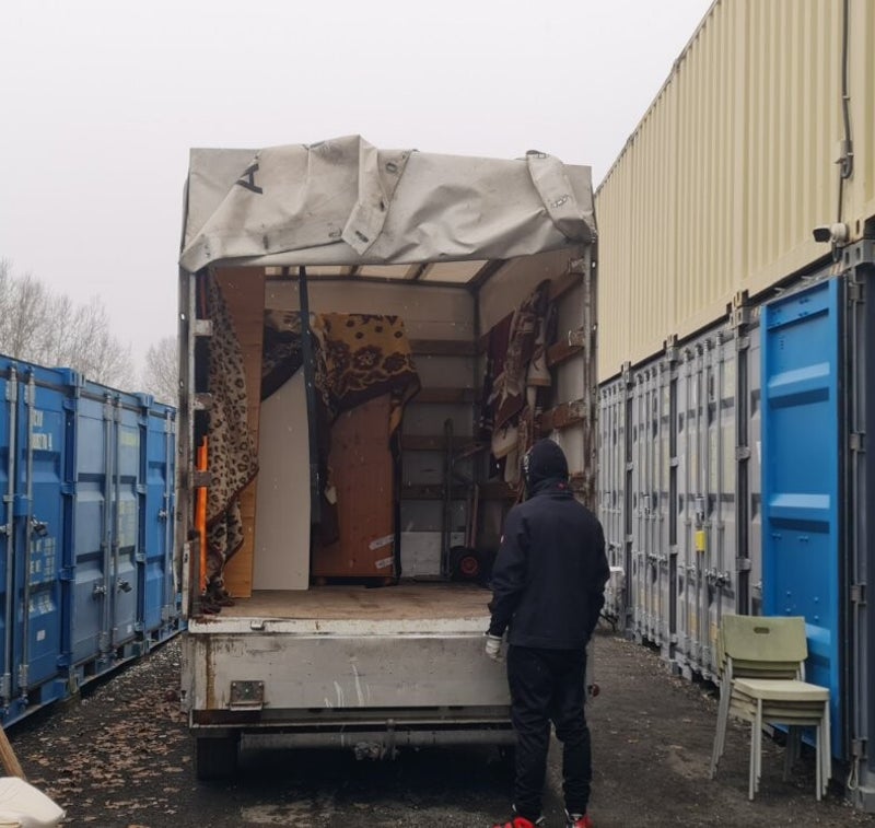 Ponyvás kisteherautóba való rakodás konténertelepen