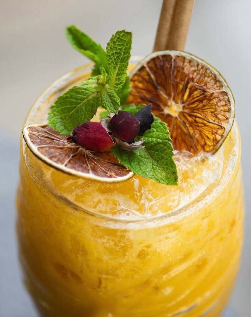 Cocktail orange garni de canneberges et menthe, création W&Co CHR Business Coaching