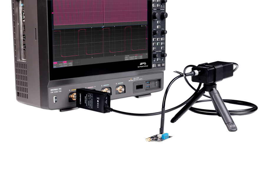 An ODP6000B series receiver plugged into an oscilloscope channel, fibre running to the probe head on its tripod above a small power converter board