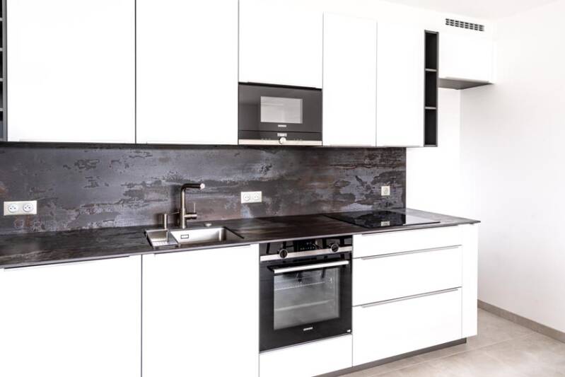 Modern white kitchen with black countertop.