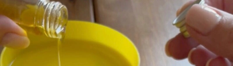 Leinöl-Firnis wird aus einem kleinen Glasfläschchen in eine flache gelbe Schale gegossen – für die spätere Holzpflege.