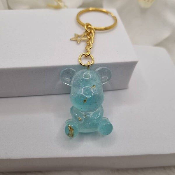 Porte clé ourson turquoise,  or er fleurs blanches 24