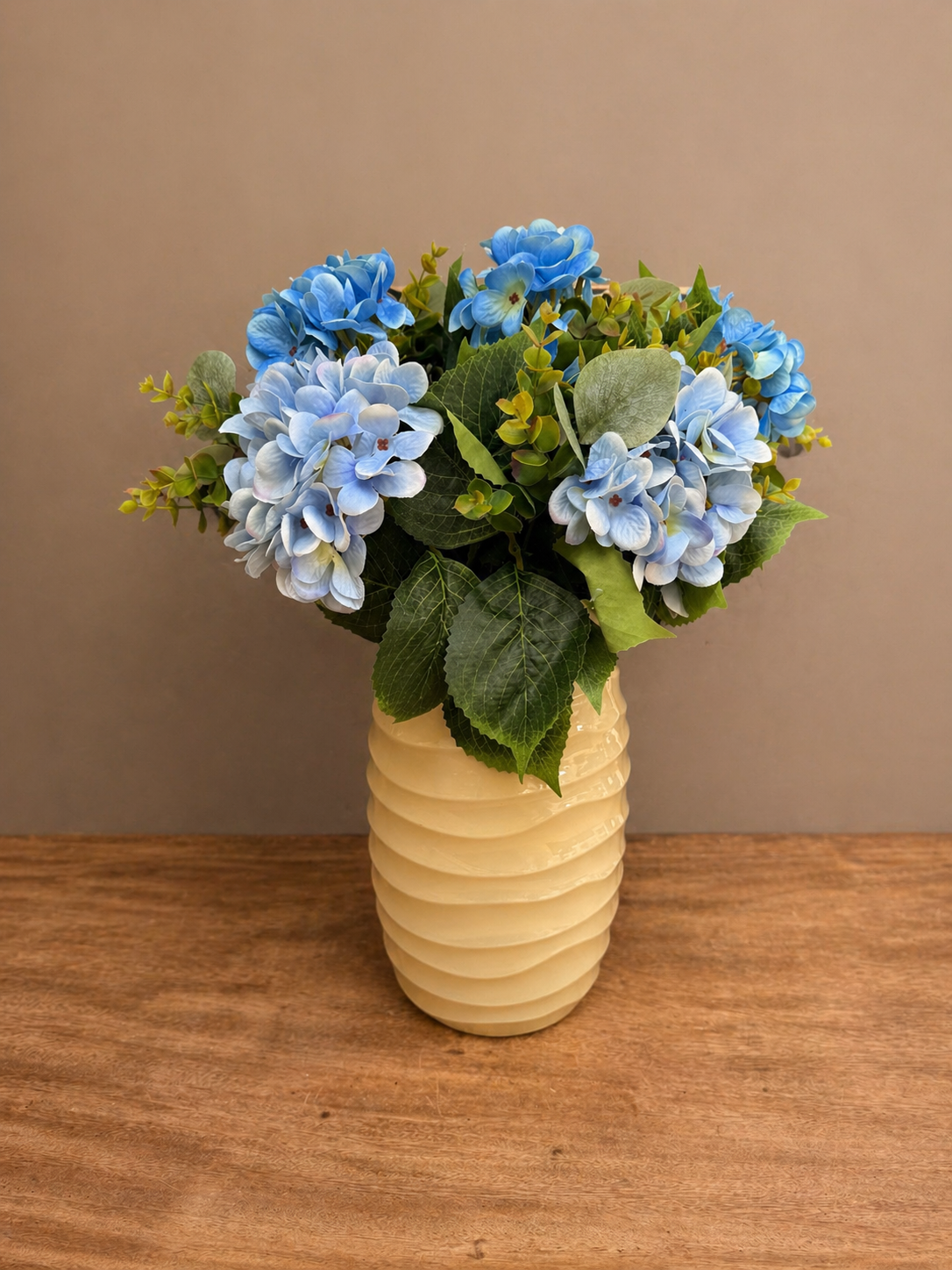 Kunstboeket hortensia blauw in gele glazen vaas