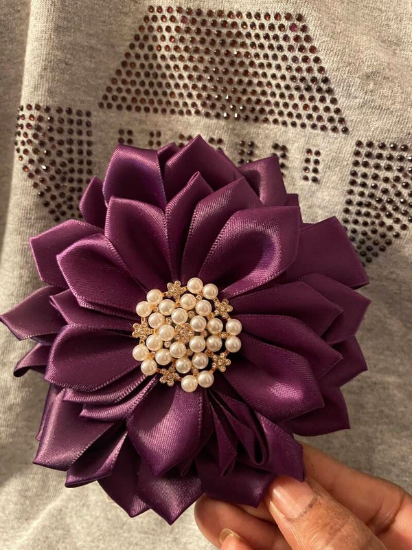 Purple corsage centered with  white pearl brooch