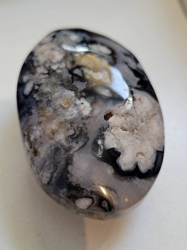 ZWARTE BLOEMAGAAT PALMSTEEN 6 CM Agaat is een steen die stabiliseert, aardt en beschermt. Ze bevordert innerlijke rust en zorgt daarmee voor een aardse nuchtere houding. Maar daar houden de eigenschappen van deze beschermende steen nog lang niet op. Spiri