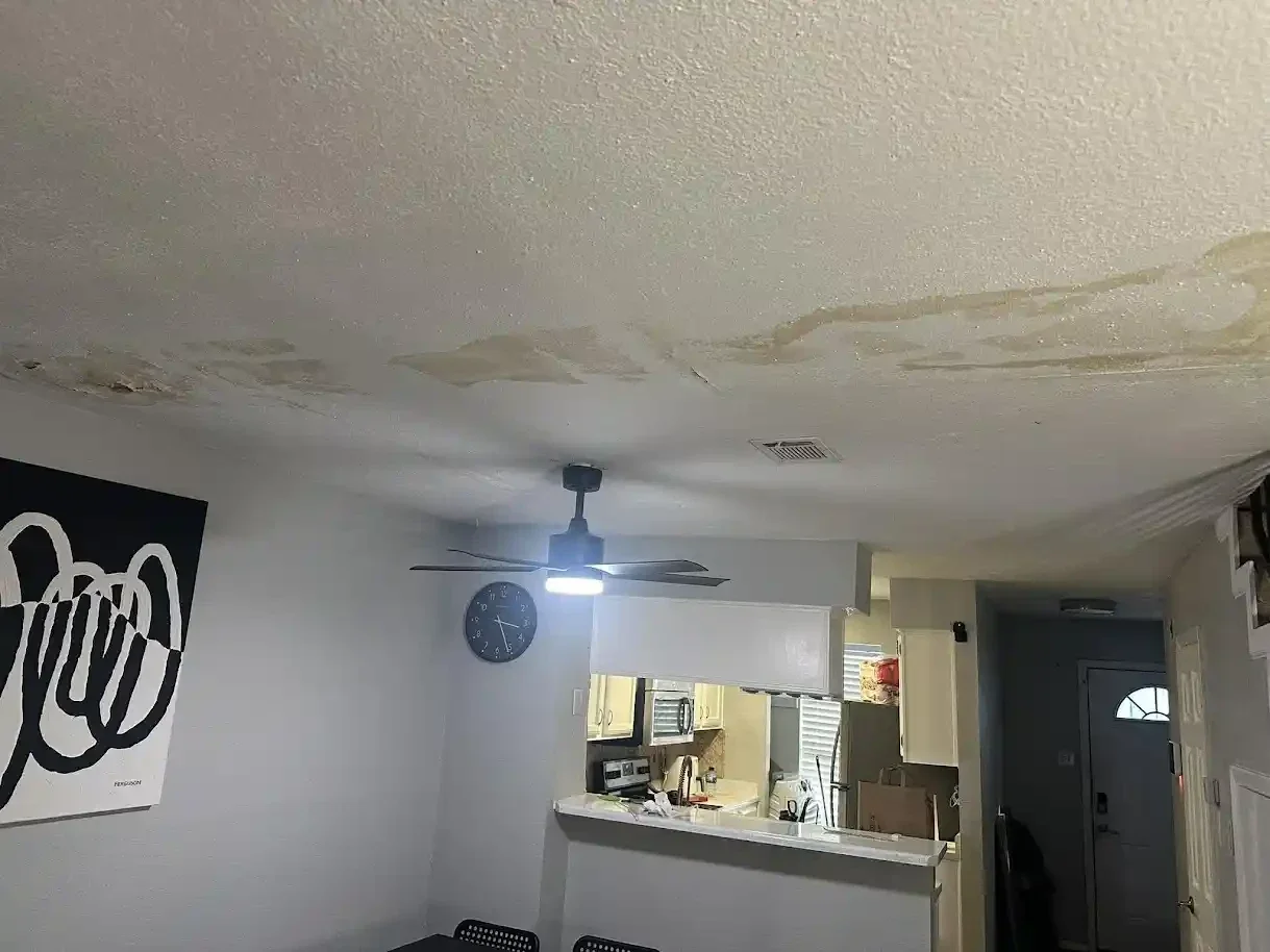 dining room ceiling showing heavy stains from bathroom leak upstairs