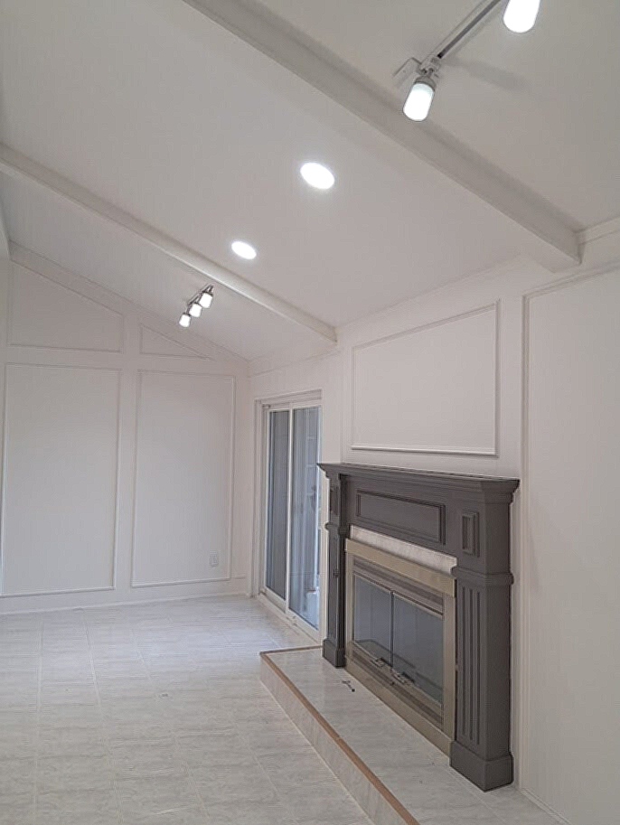 smoorh vaulted ceiling with modern lupdates to light and dark accent on fireplace
