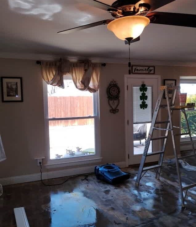 water all flooded over the living room of a home after removing flooring and settting up industrial air movers and air scrubbers