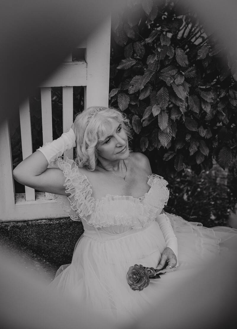  artystyczna fotografia kobieca blisko Chełmna i Świecia. Monochromatyczny portret pełen klasy przedstawiający kobietę w długiej sukni z gorsetem i koronkowymi rękawiczkami na tle parkowych liści