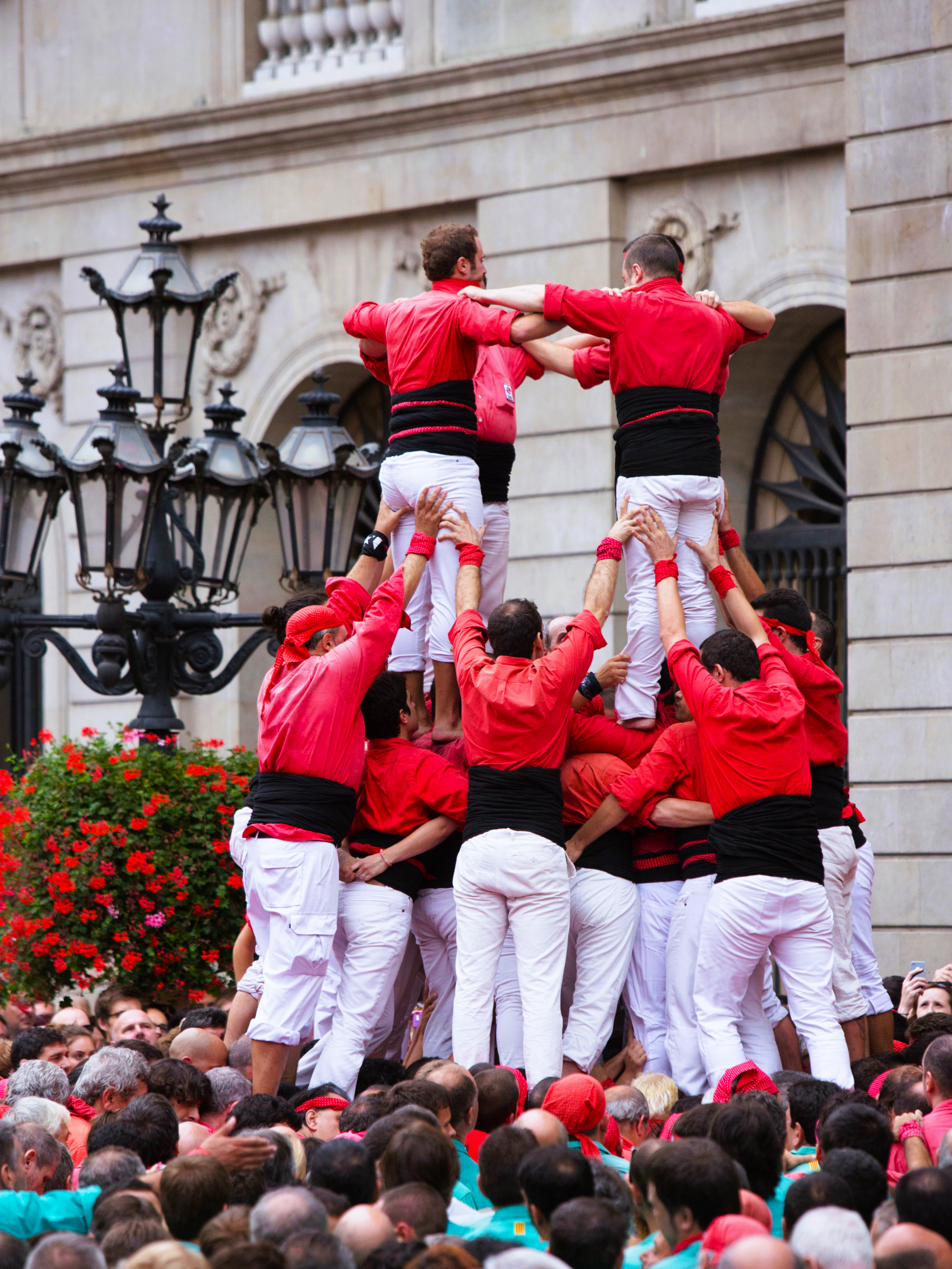 Mensentoren op La Mercè in Barcelona. Ze dragen witte broeken en een rood hemd.