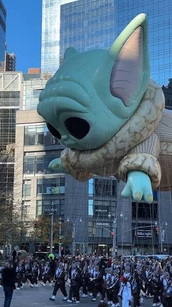 Een grote ballonfiguur zweeft aan touwen door de straten van New York City tijdens de Macy’s Thanksgiving Day Parade
