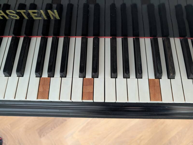 Bechsteinflygel där tangentbelägg har lossnat