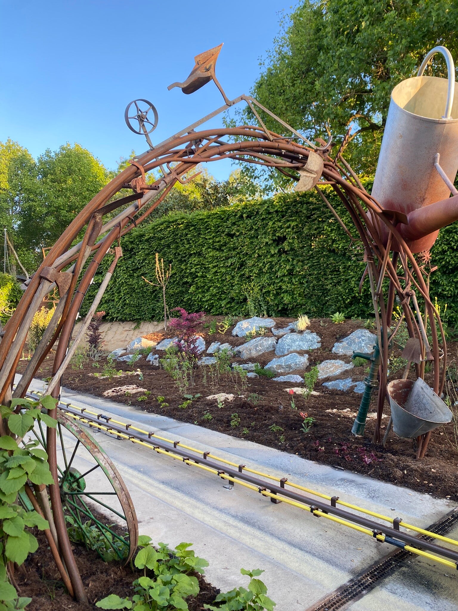 Arche métallique monumentale avec des outils de jardin