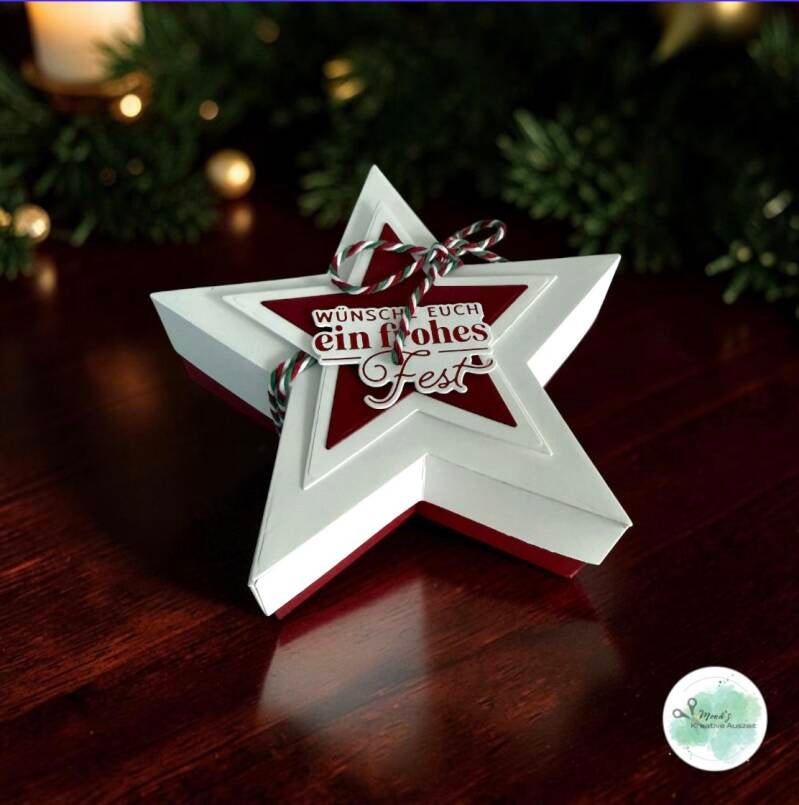 Weiße Sternenschachtel mit roter Weihnachtsdekoration