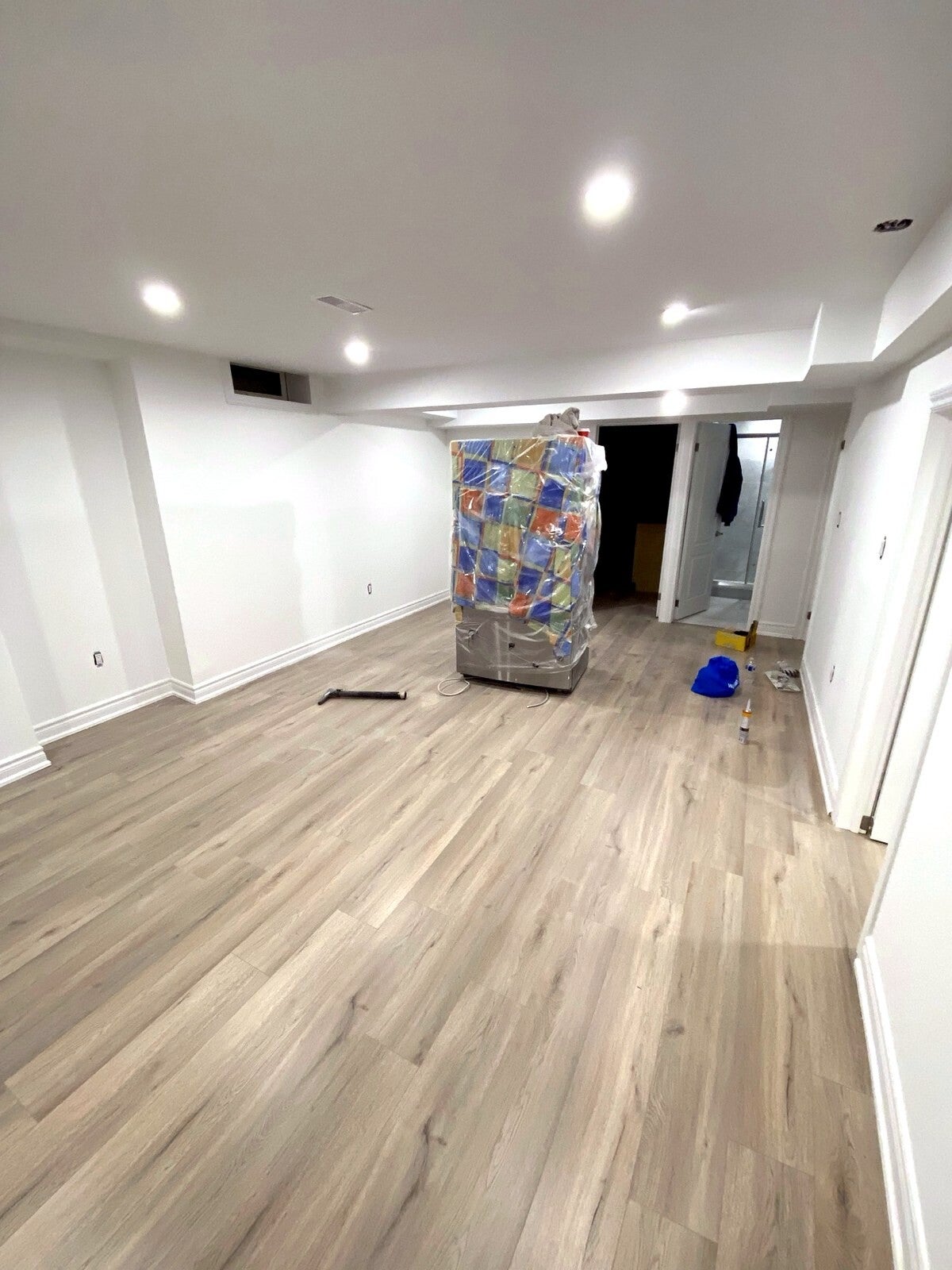 Finished basement with vinyl plank flooring and pot lights — Perfect Finish Pros, Calgary