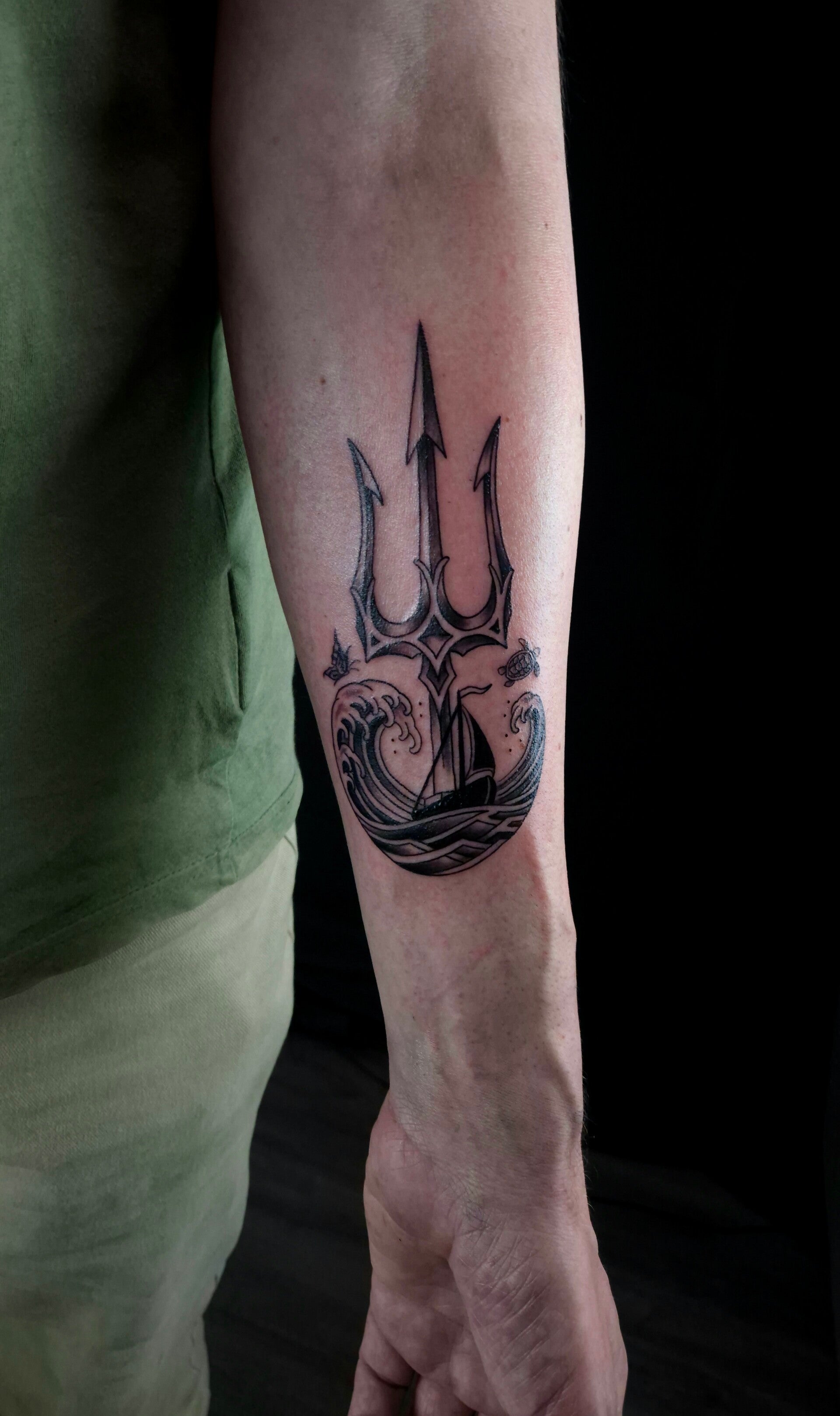 Minimalistische drietand tattoo met golfpatroon Drietand en golven tattoo op onderarm