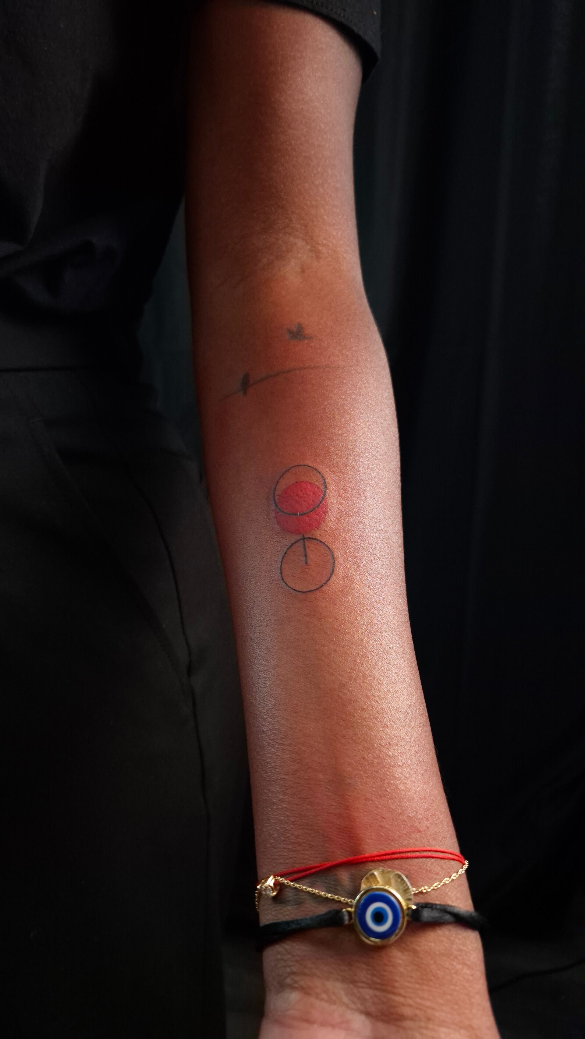 Subtiele minimalistische tattoo bij Tattoo Dos Santos Minimalistische cirkels tattoo op de arm