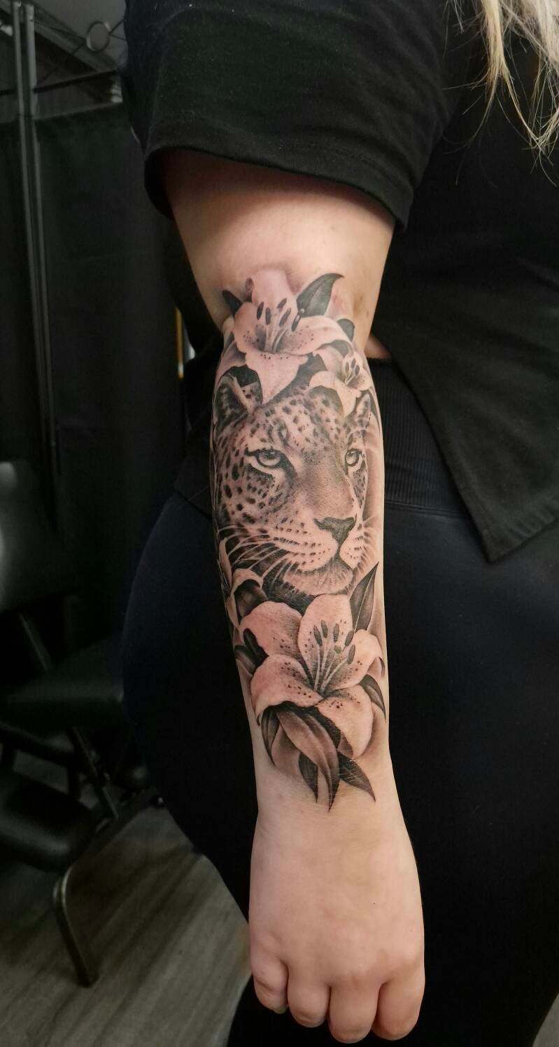 Black & grey panter met lelies op de onderarm