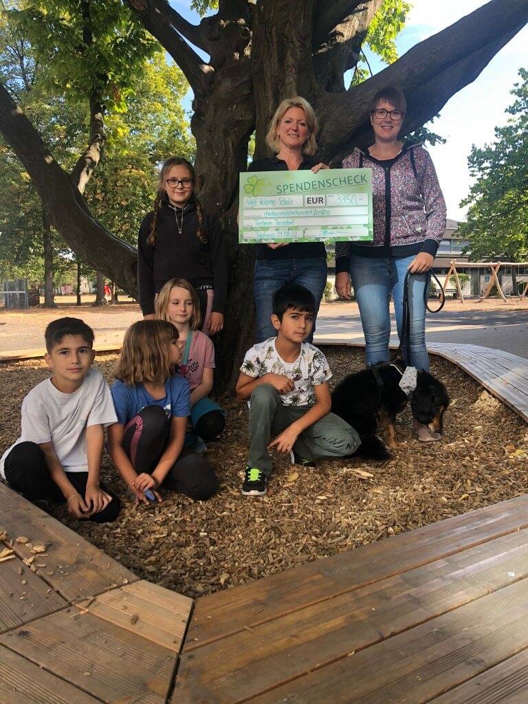 Eine Gruppe Kinder mit einem Scheck für das Tierheim
