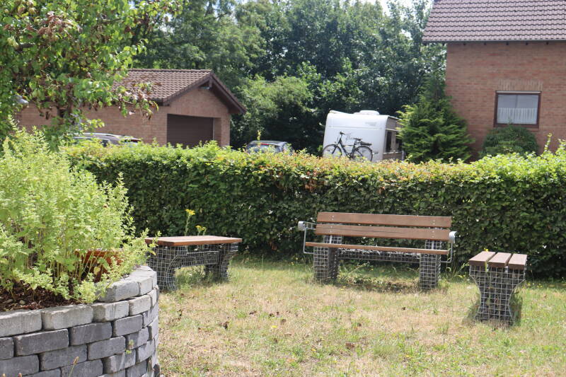 Schulgarten mit Bänken und Kräuterspirale