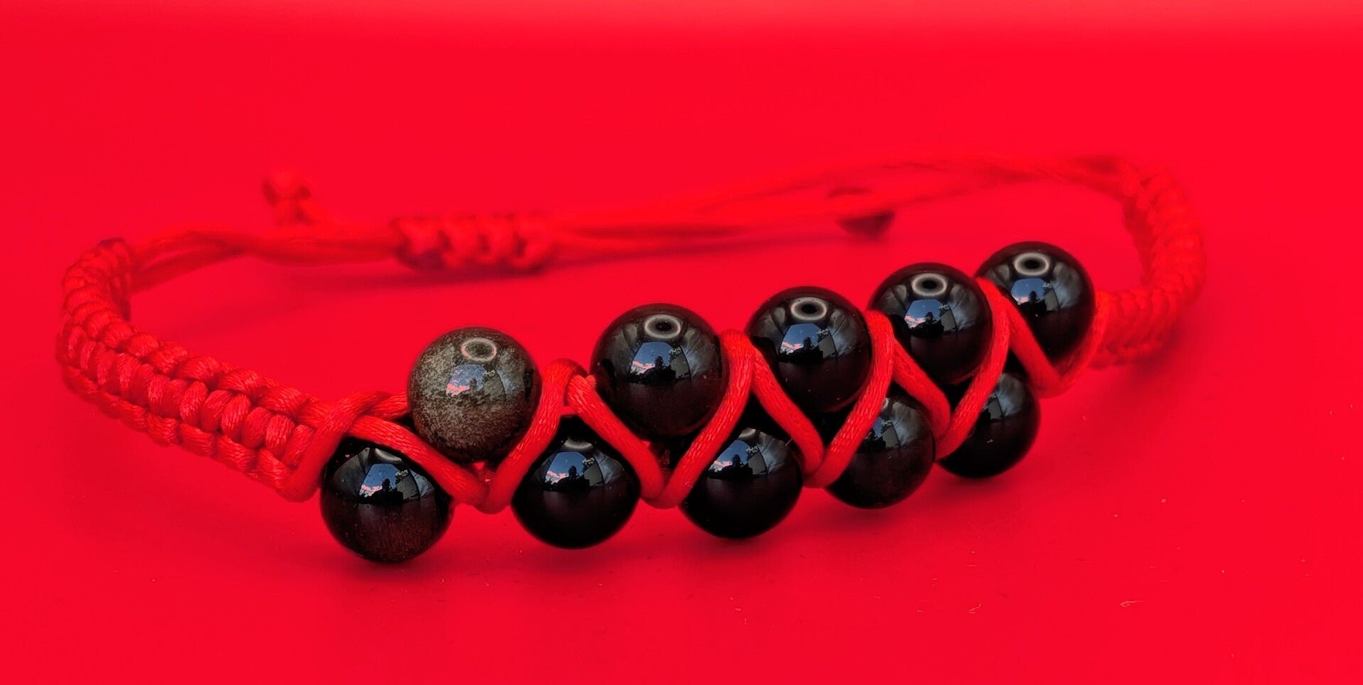 Bracelet obsidienne dorée 10 perles fil rouge