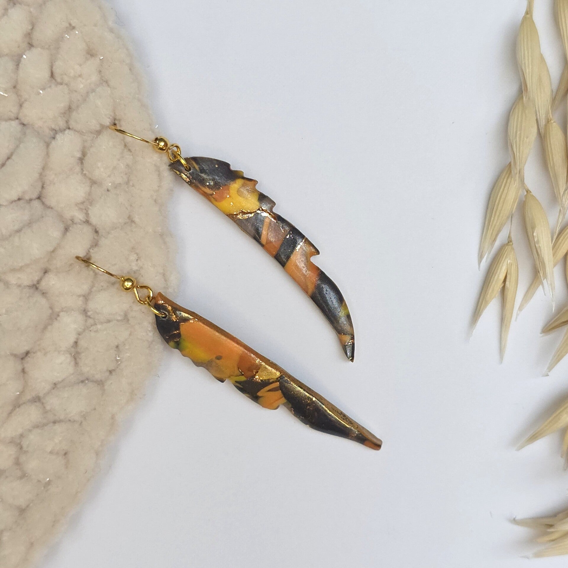 Halve veren oorbellen in herfstkleuren aan RVS oorhaakje