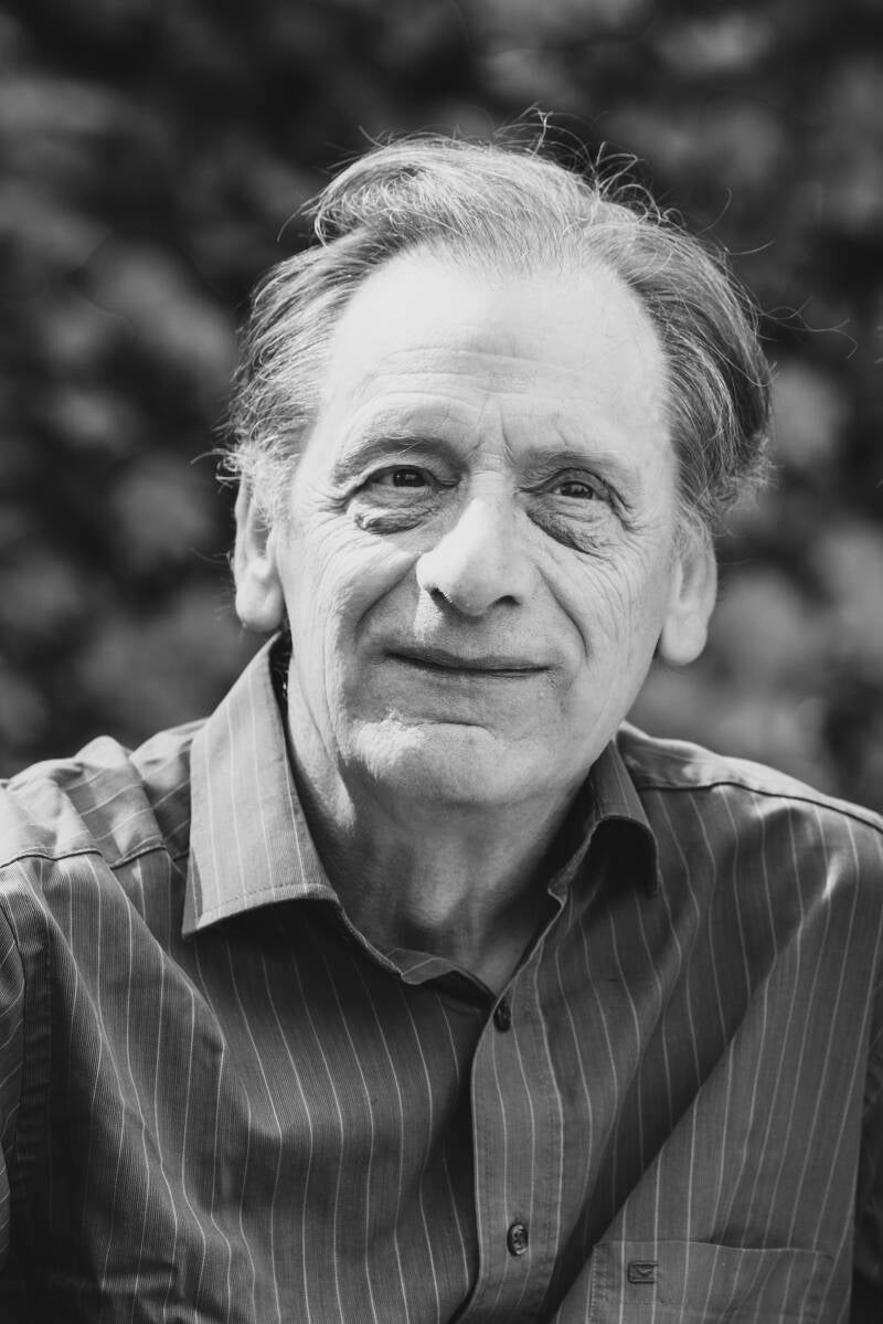 Zwart-wit portret van een oudere man met rustige blik. Liefdevol vastgelegd als waardevolle herinnering, onderdeel van een fotoserie met seniorenportretten.