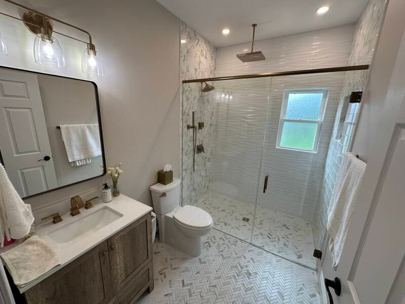 Bathroom renovation with custom walk-in shower, warm wood vanity and white tile in Monmouth County NJ