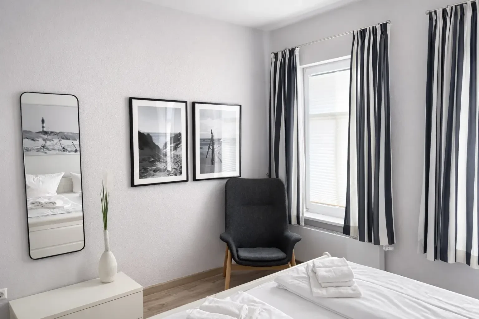 Schlafzimmer der Ferienwohnung Ille auf Amrum mit Doppelbett und hellem, modernem Ambiente