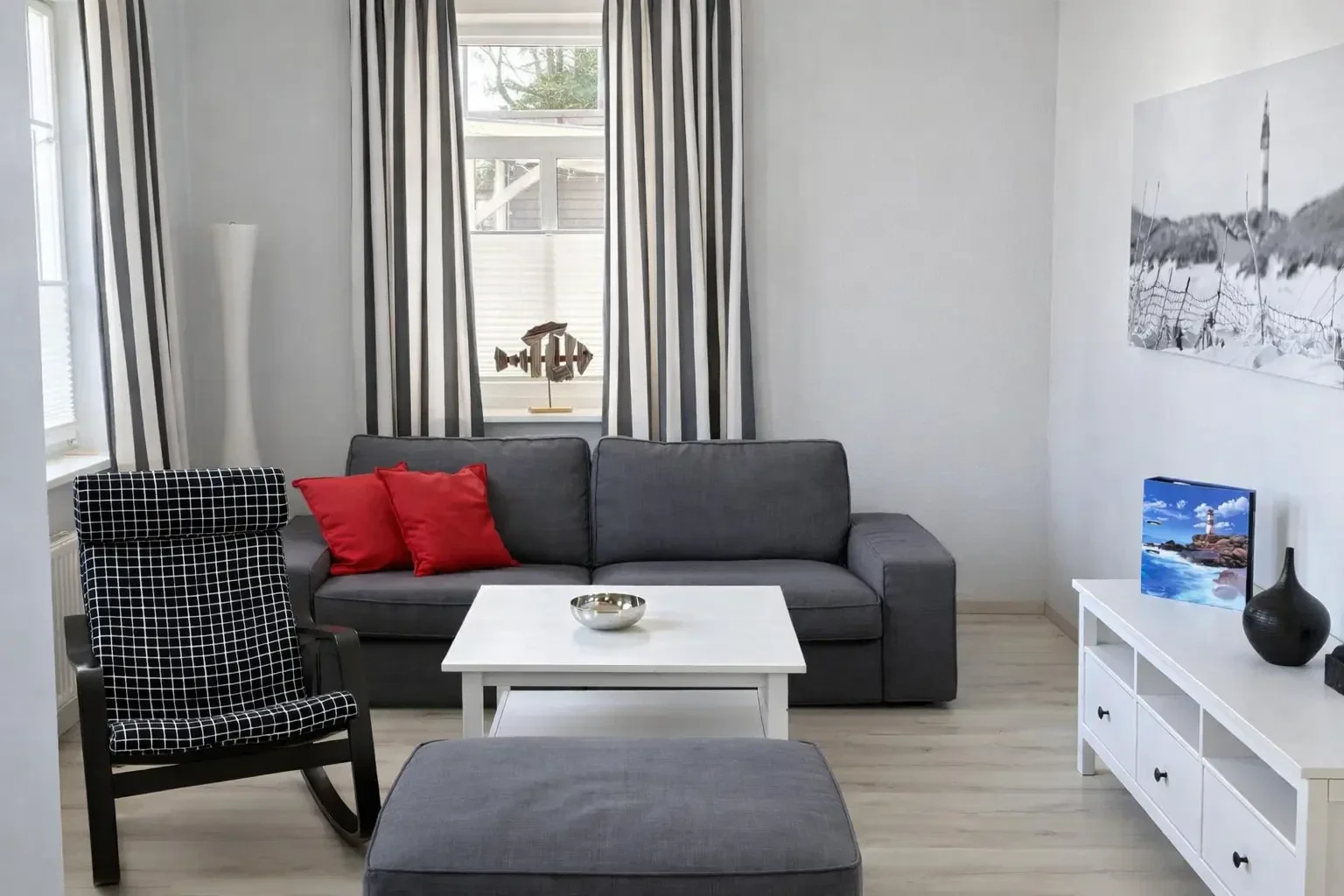 Wohnzimmer der Ferienwohnung Martha auf Amrum mit Sofa, Sessel und hellem Wohnbereich