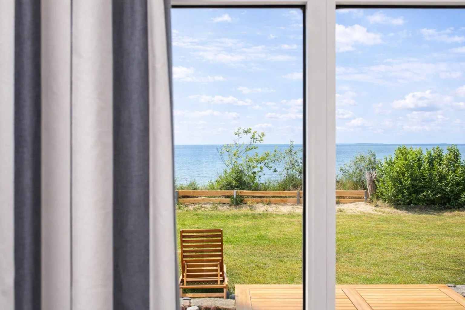 Meerblick aus dem Wohnzimmer der Ferienwohnung Martha auf Amrum mit Blick auf Garten und Nordsee