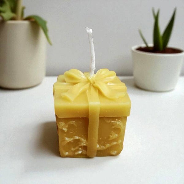 Candela a forma di pacchetto regalo, in pura cera d'api.
