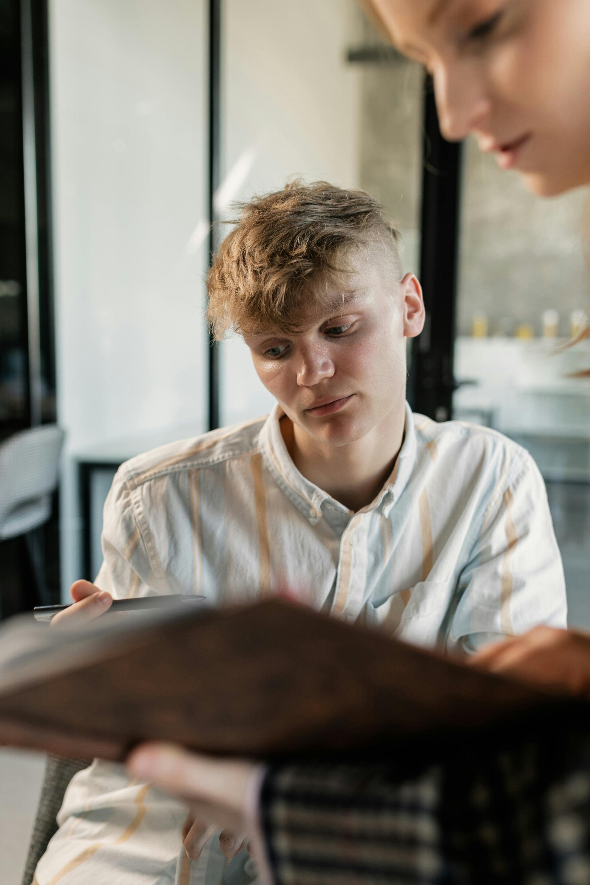 Geconcentreerde blonde leerling denkt na over zijn studiekeuze