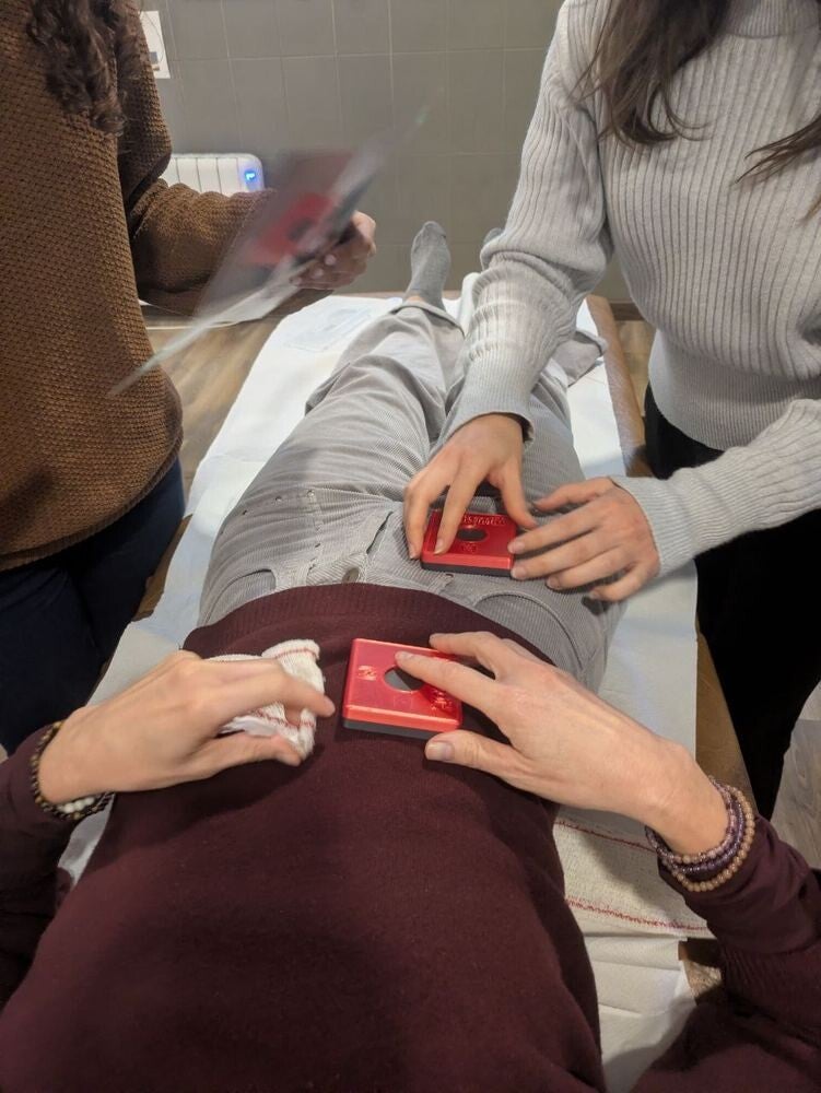Participantes colocando un imán sobre el abdomen durante la práctica