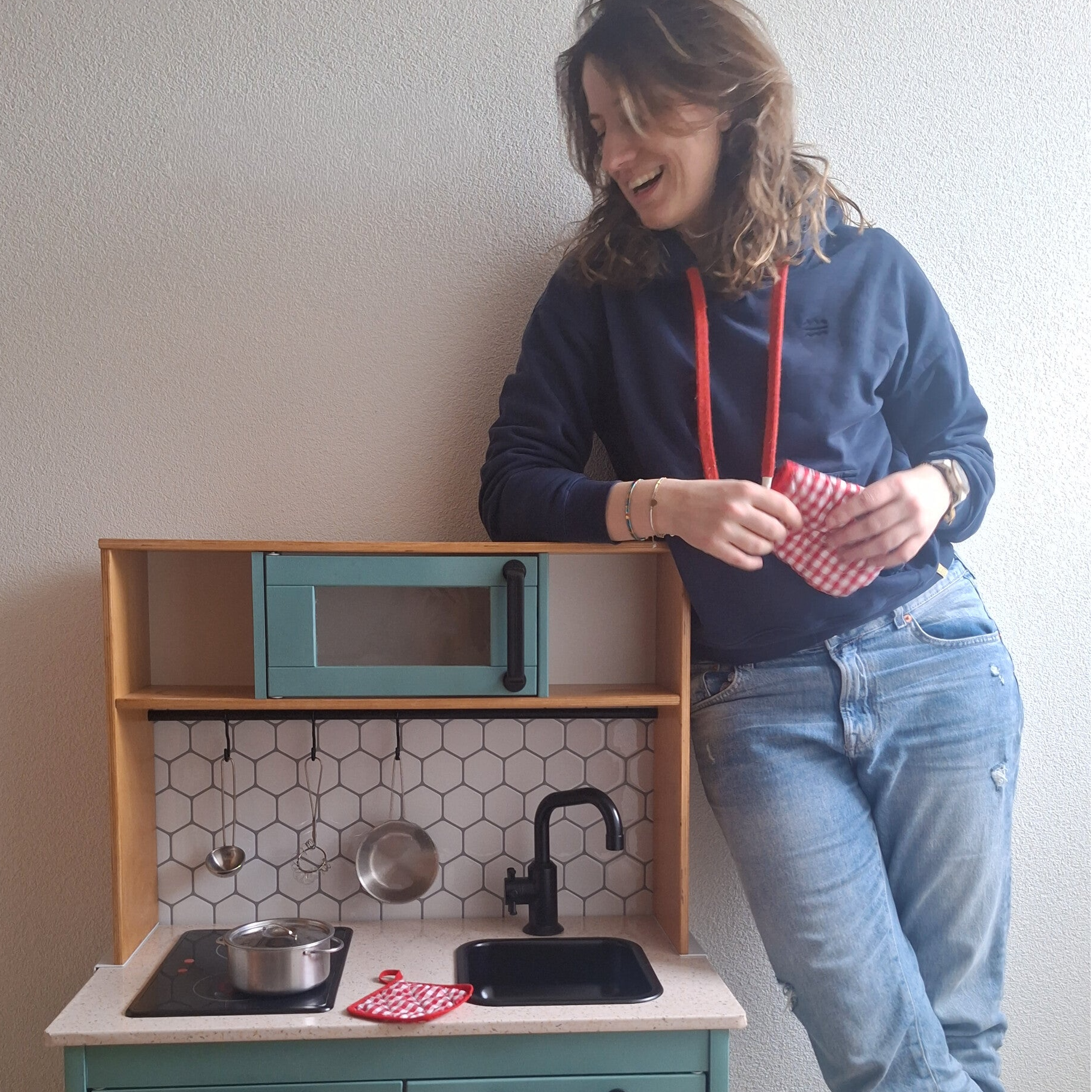 Manon van BIMBT naast een gerestylde IKEA DUKTIG speelkeuken.