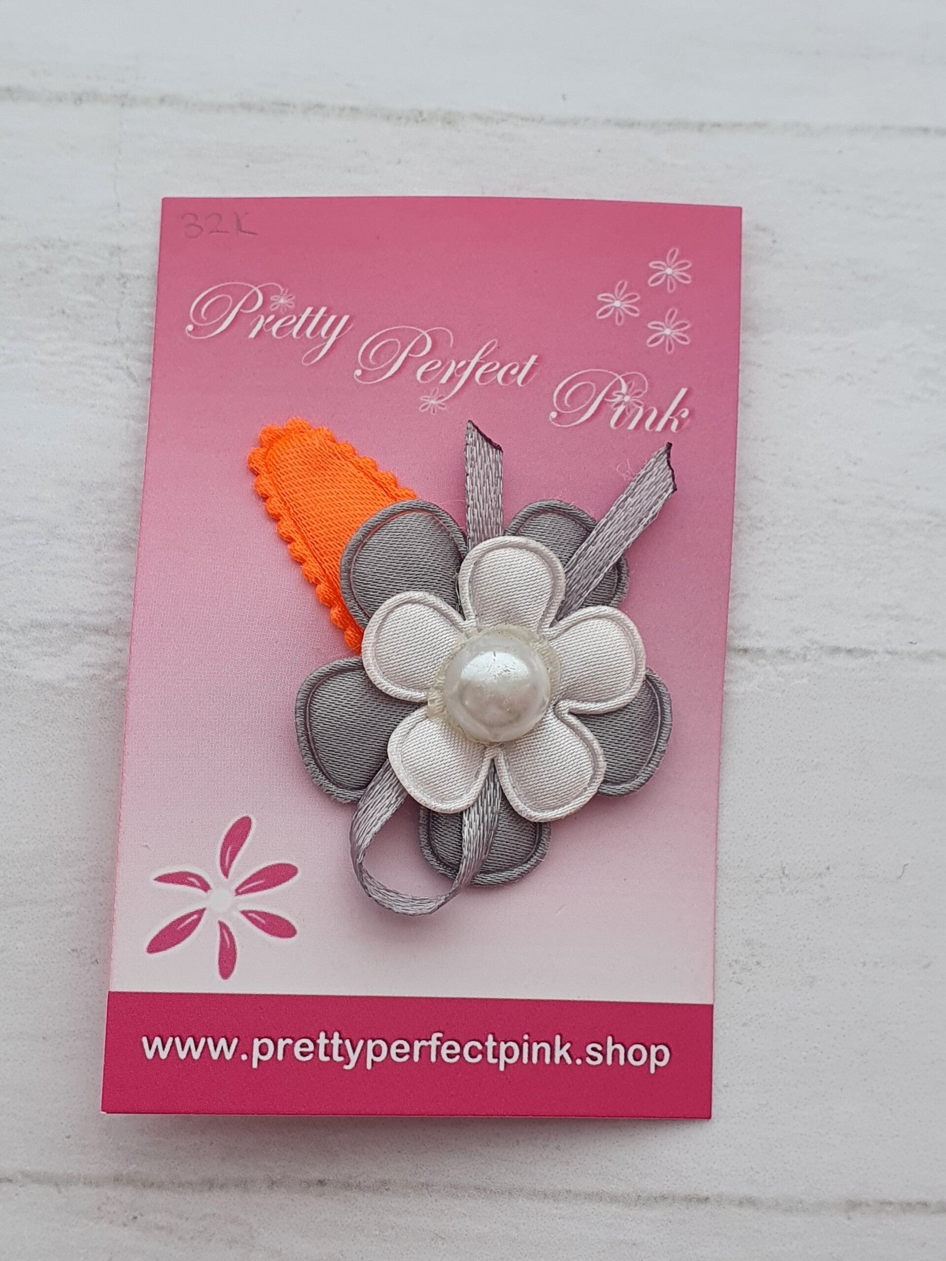 Neon oranje haarspeldje met bloemetjes