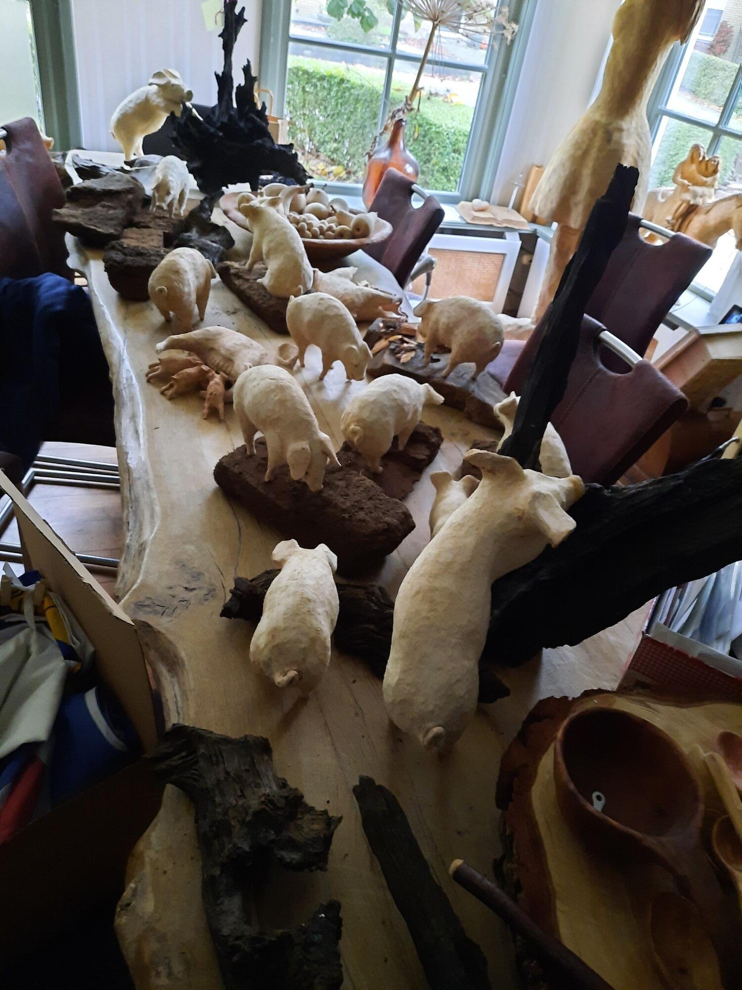 Houtsculptuur van een tafel vol varkens