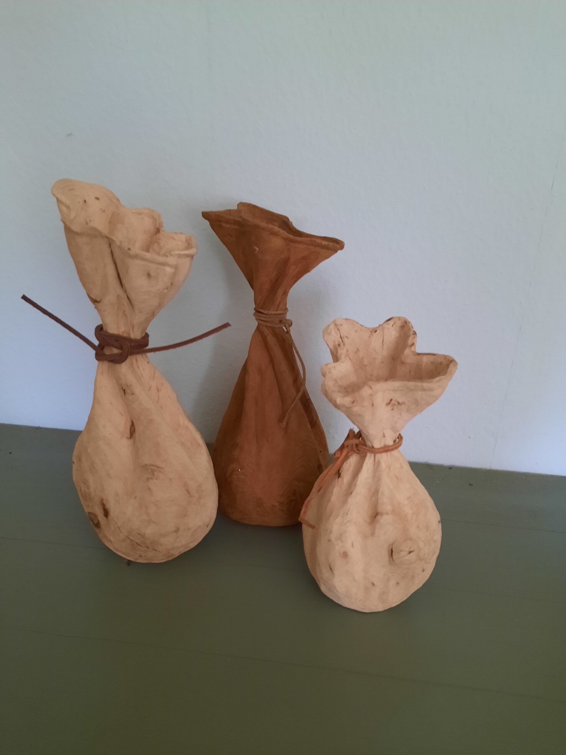 Houtsculptuur van dichtgebonden geldzakjes
