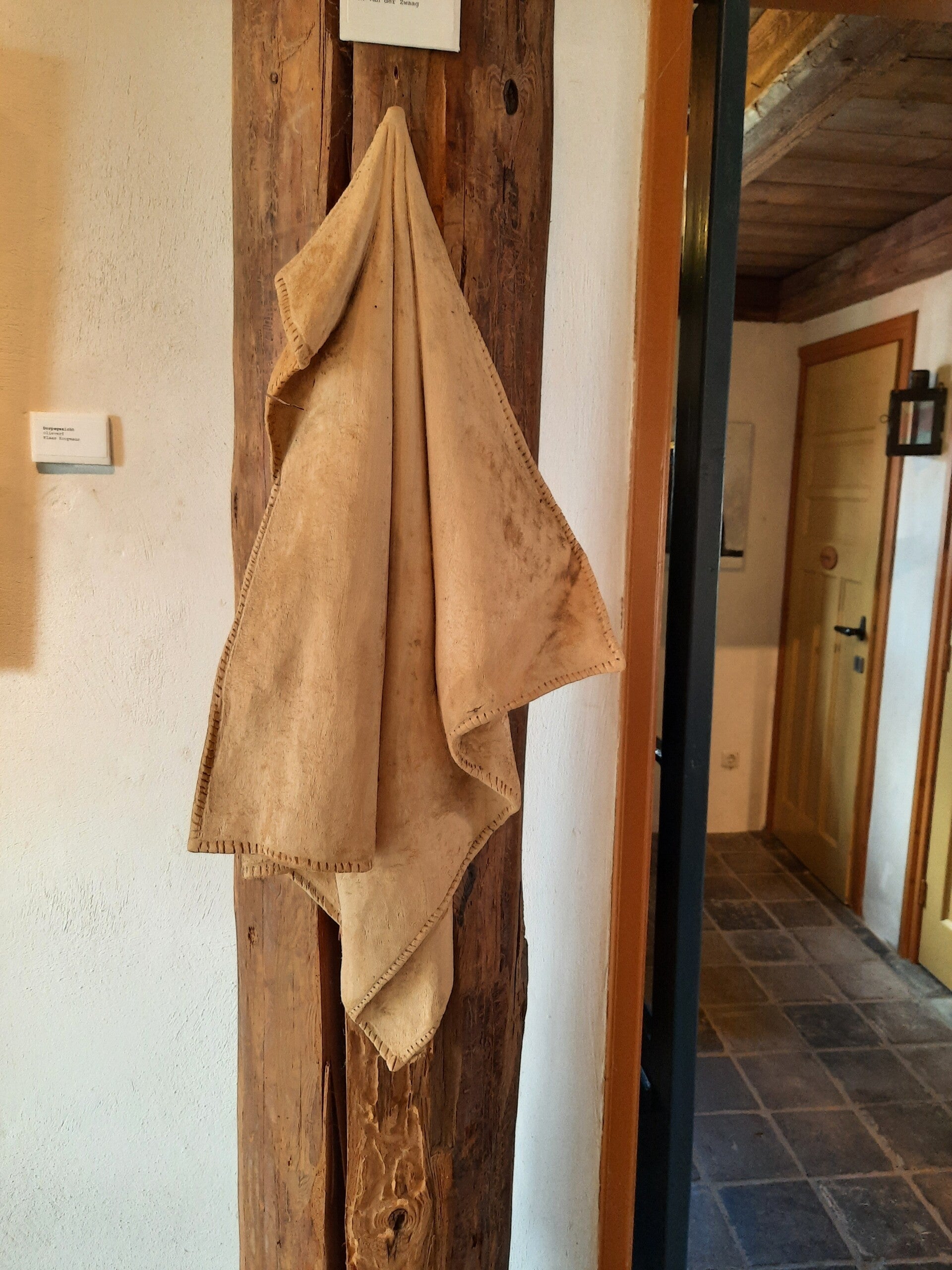 Houtsculptuur van een handdoek op gehangen aan een spijker