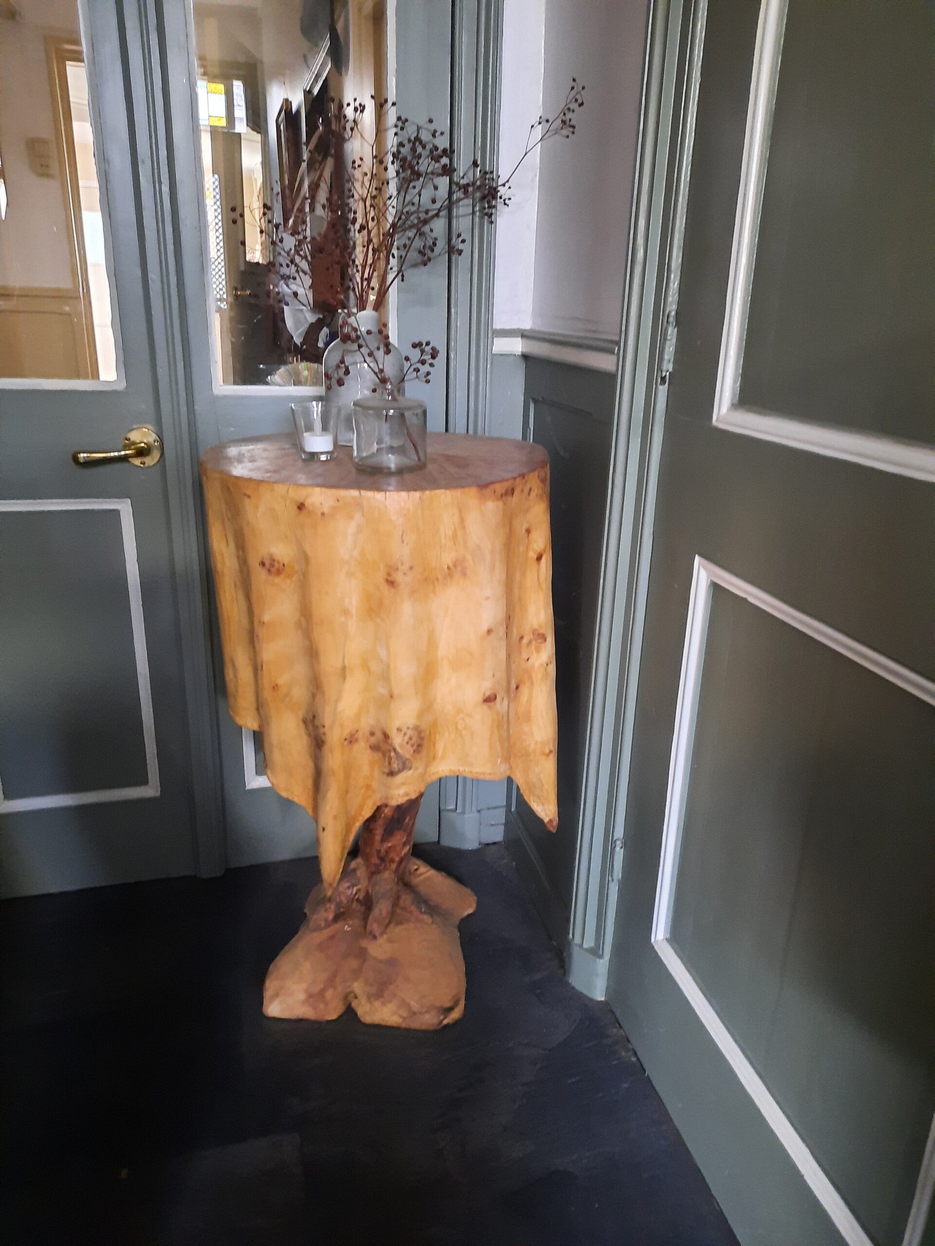 Houtsculptuur van een tafeltje met geplooid tafelkleed