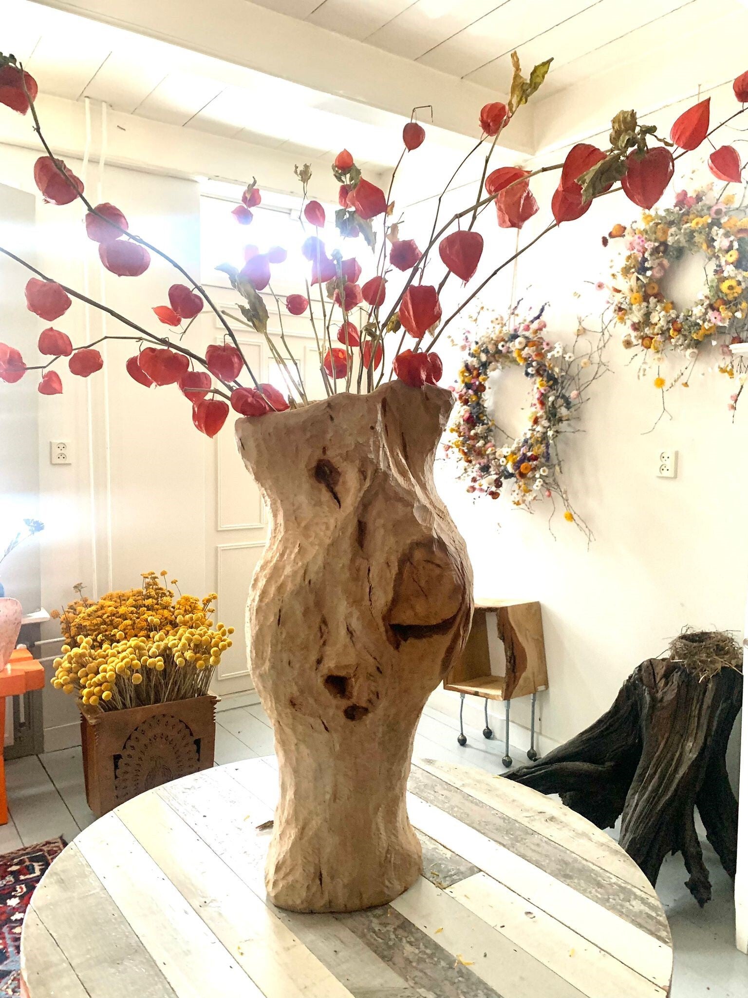 Houtsculptuur van een vaas met droogbloemen