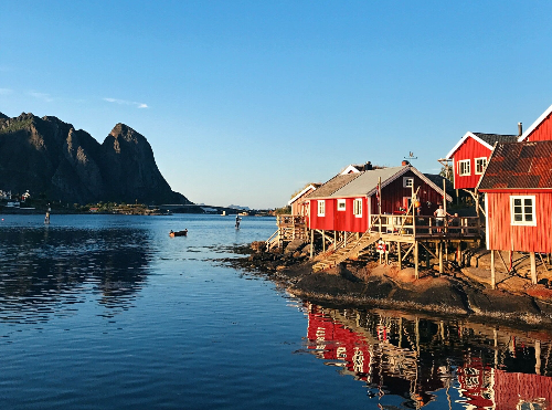 Rode vissershuisjes aan het water met steile bergen op de Lofoten in Noorwegen