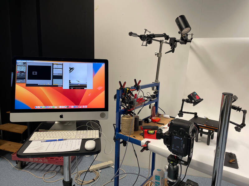The image shows the set up within the studio, showing the camera placement, the subject placement and the apple mac computer from where the image is captured