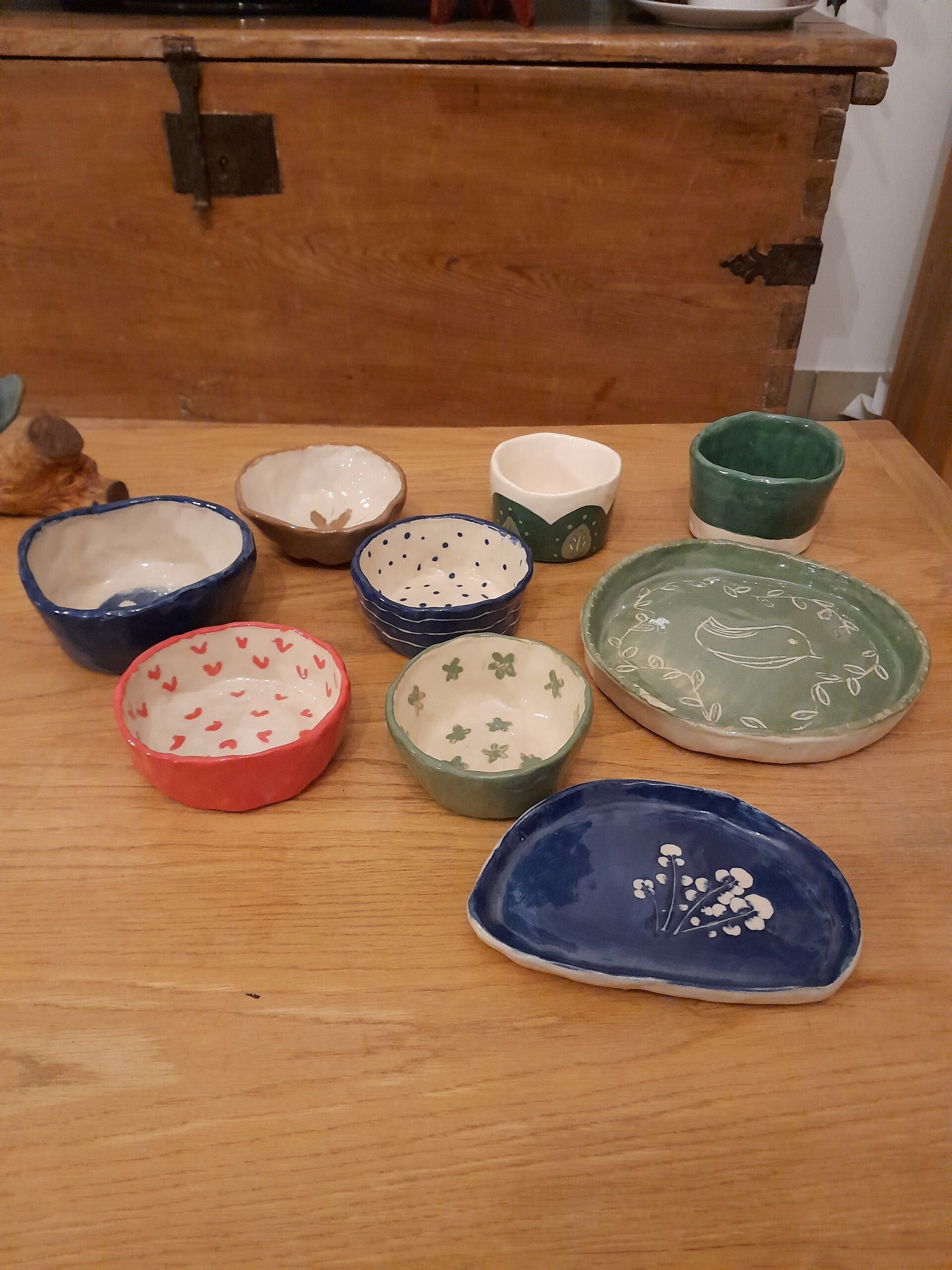 Poteries réalisées lors d'un atelier modelage. Petits bols et assiette en céramique, peint à la main à l'engobe de couleur.