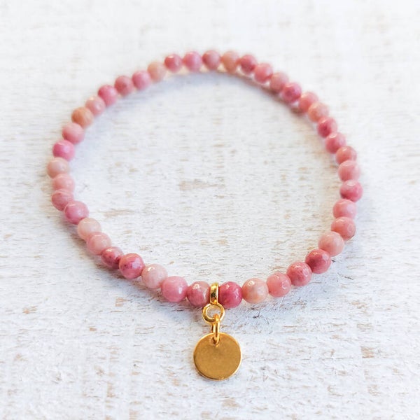 Armband van 4 mm rhodoniet gefacetteerde kralen met goudkleurig bedeltje