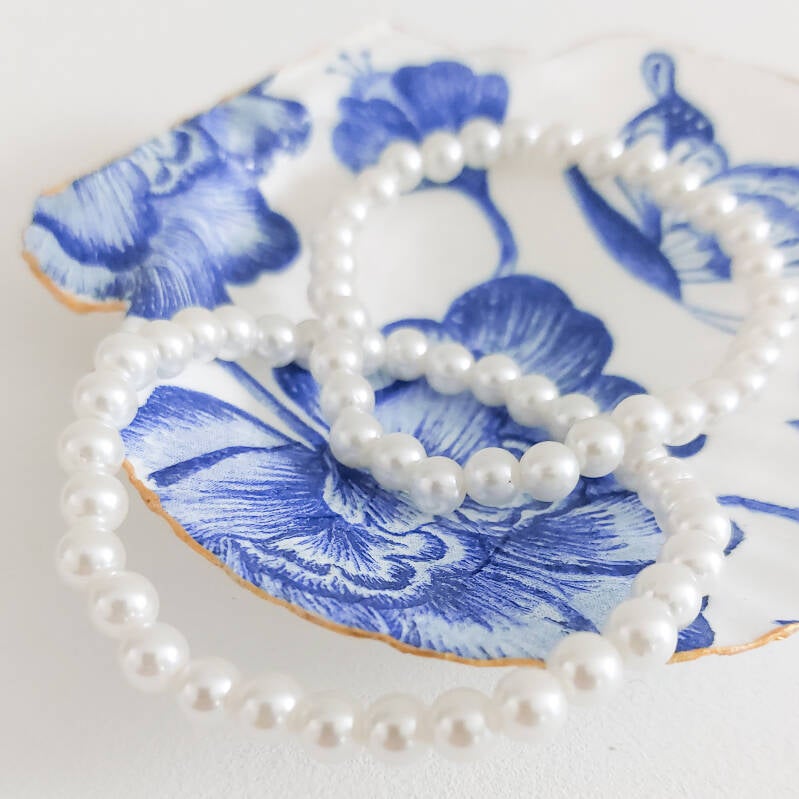 foto van een met decoupage gedecoreerde schelp. Delfts blauwe bloemen met parel armbanden ter decoratie